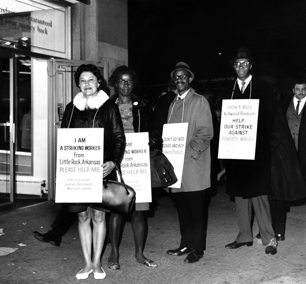 African American and Hispanic American workers on strike against Kellwood in Little Rock, Arkansas in 1967, wearing placards that encourage support for better wages.
