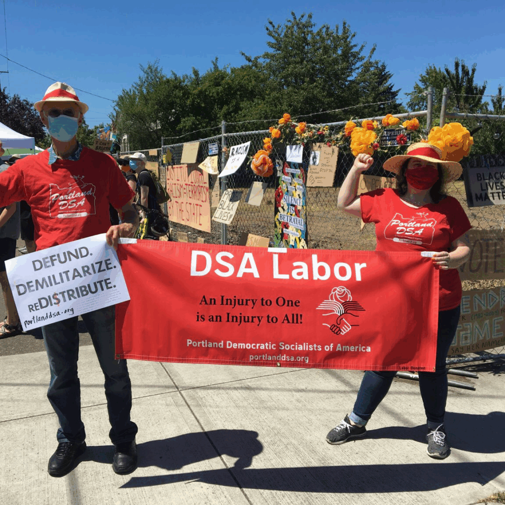 Portland DSA members holding signs and a banner that reads "DSA Labor - An injury to one is an injury to all!"